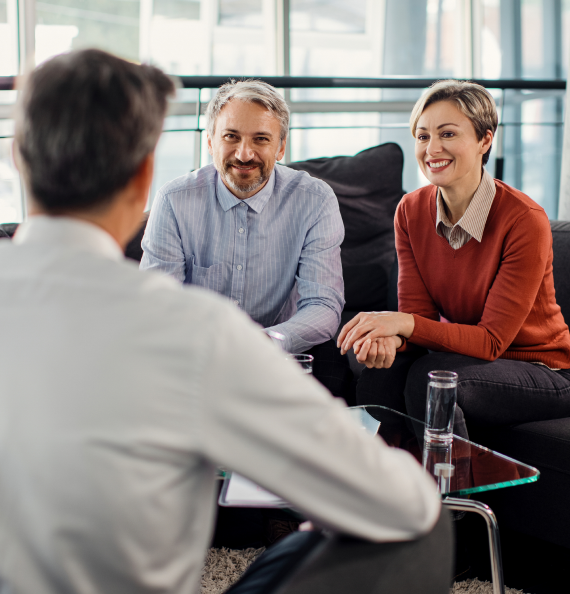 Couple reviewing financing paperwork with an advisor