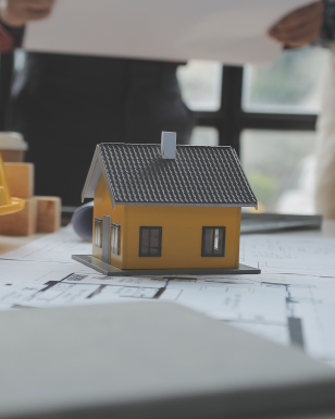 Model house on building plans during a project meeting