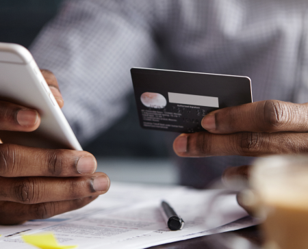 Customer reviewing payment options on a phone with a card in hand